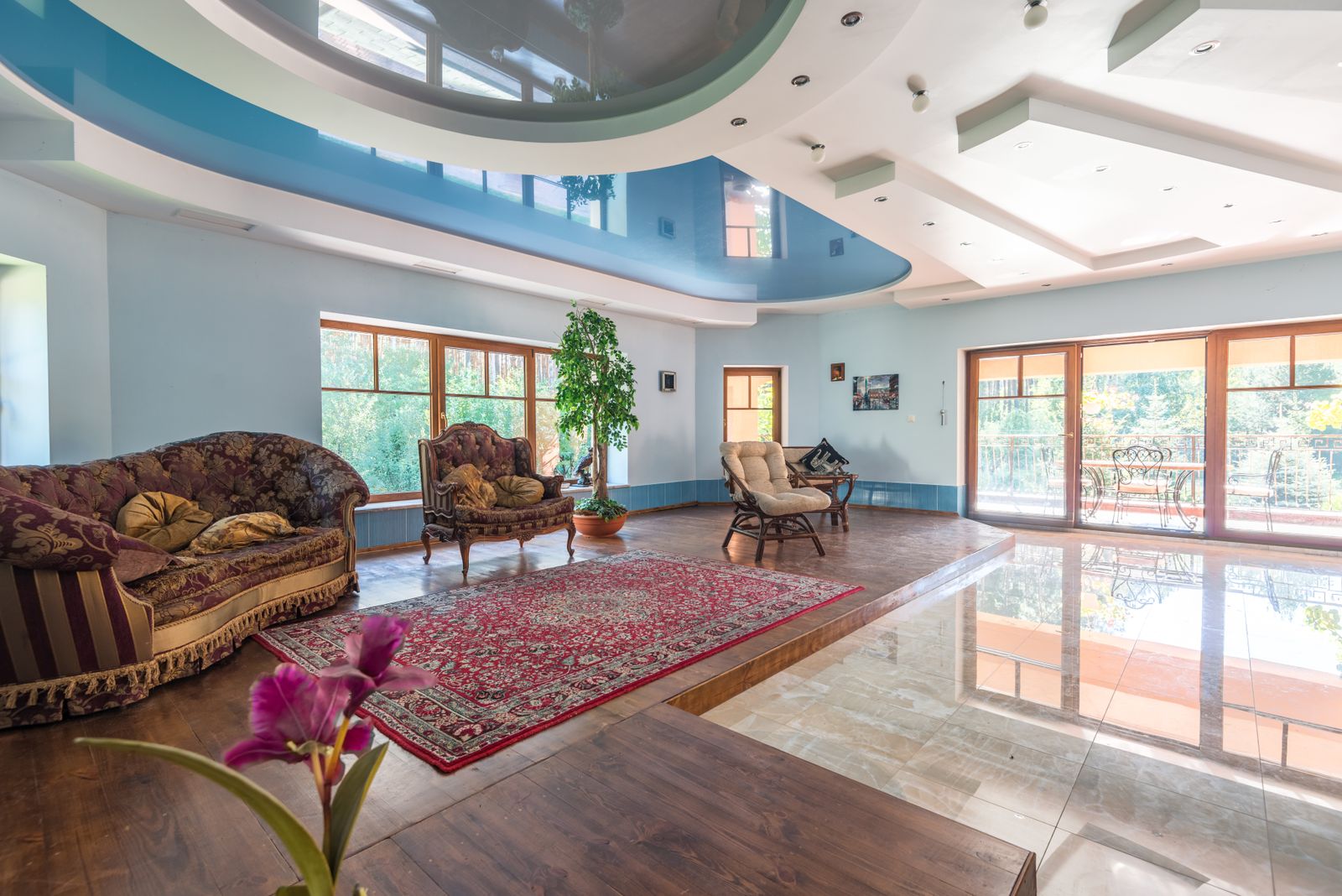 Large living room with a modern two-tone multi-level ceiling, recessed lighting, and tall windows